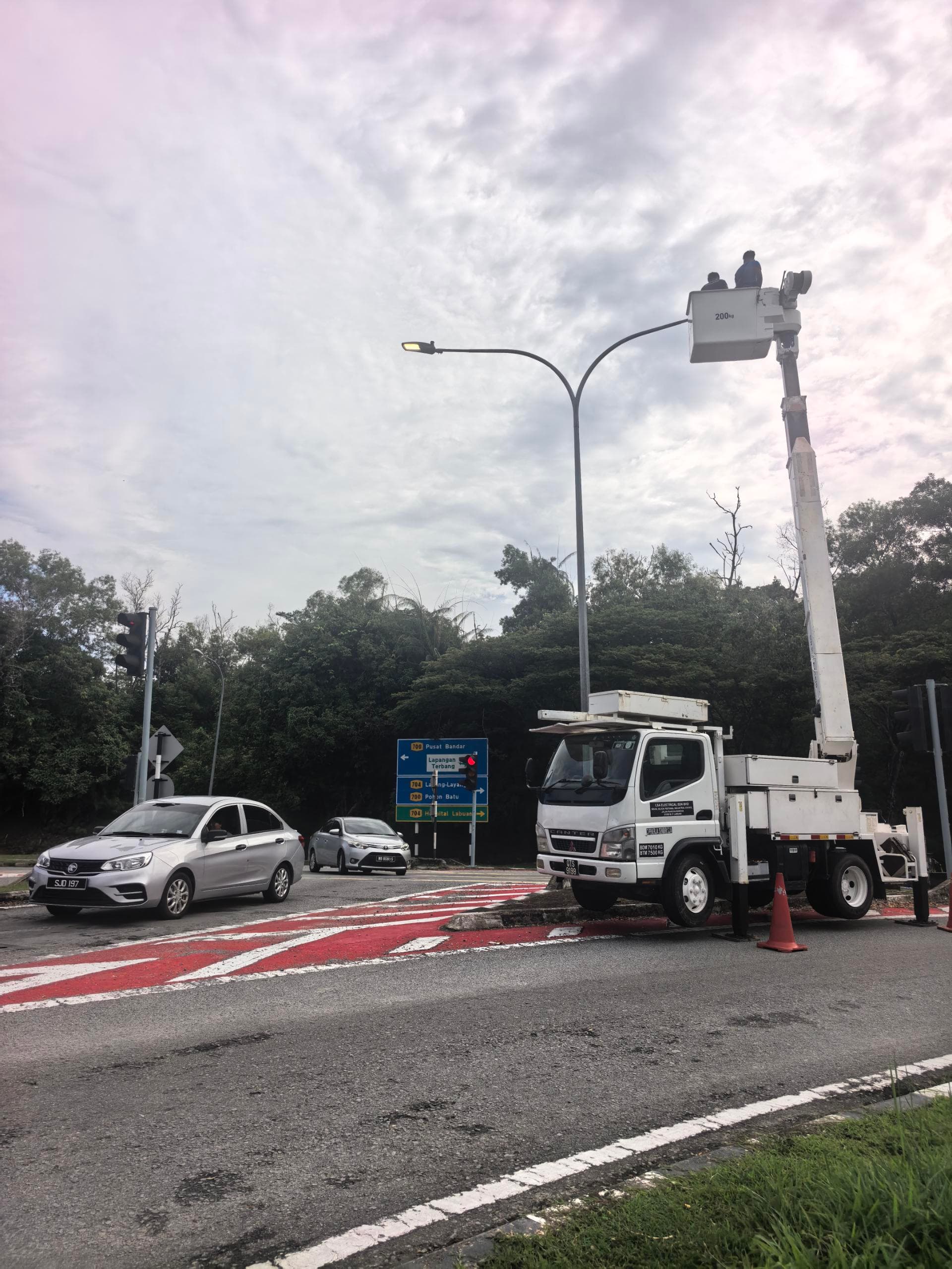 Streetlight commissioning work from a crane truck